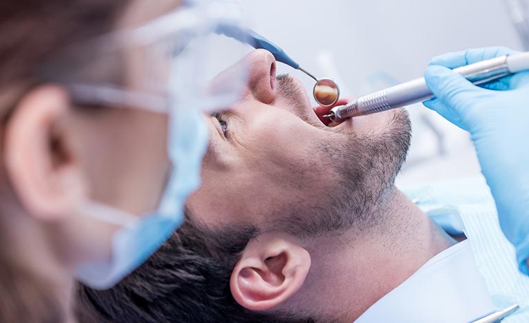 Mann bei der Zahnreinigung in der Zahnarztpraxis Stefanos Baraliakos in Berlin-Mariendorf